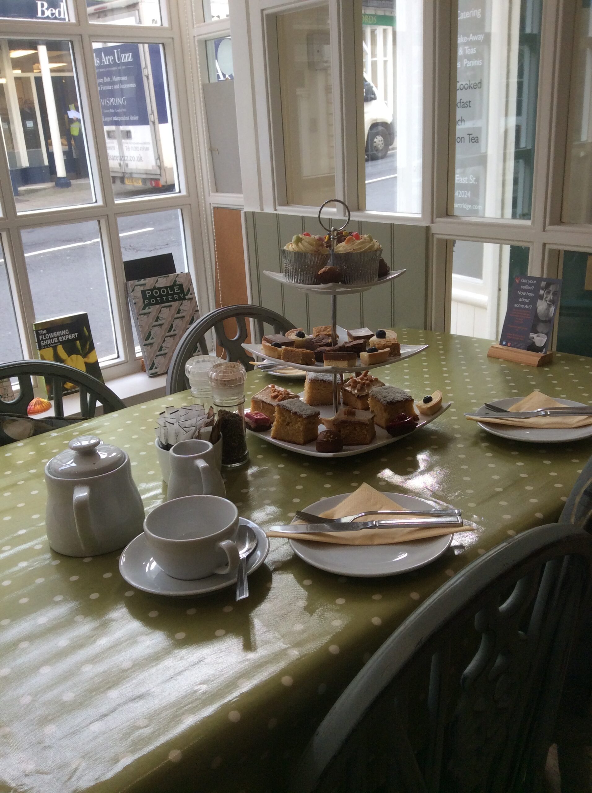 A table with tea and an assortment of cakes on stacked plates